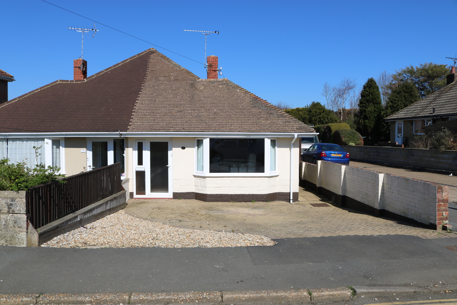 A photograph of Goldcrest Cottage showing the front aspect and driveway space for two cars on a sunny summer's day in Sandown. Isle of Wight.
